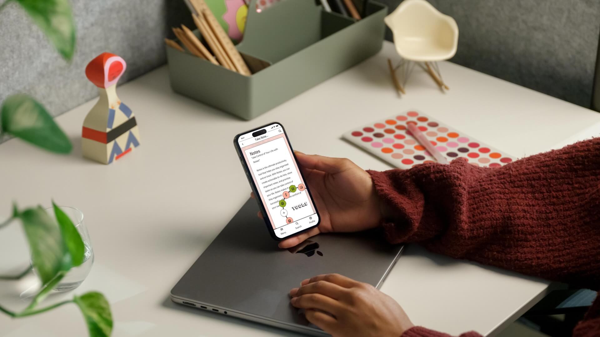 Person holding a smartphone displaying the ProcrastiGreat app home dashboard with habit tracker circles and a pastel pink interface